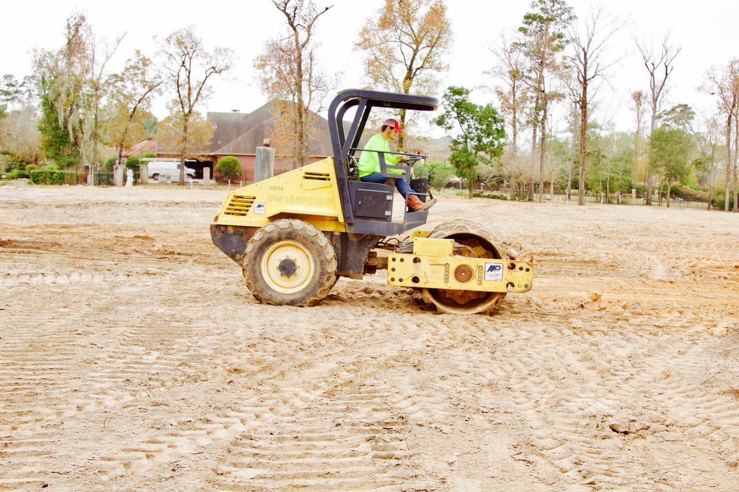A roller compacting a stabilised pad on a Houston-area site