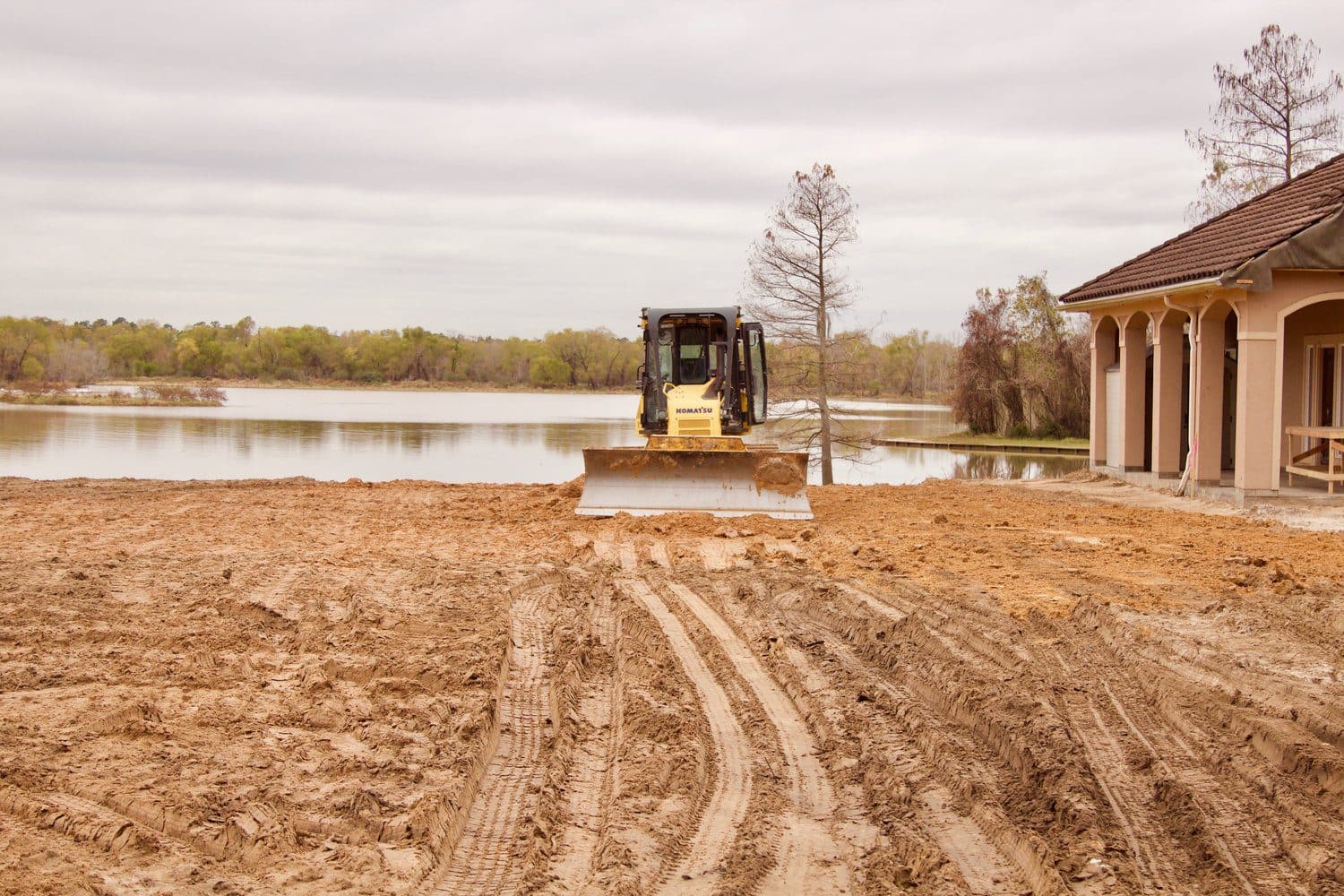 A dozer cutting grade at the water's edge on a Houston-area site